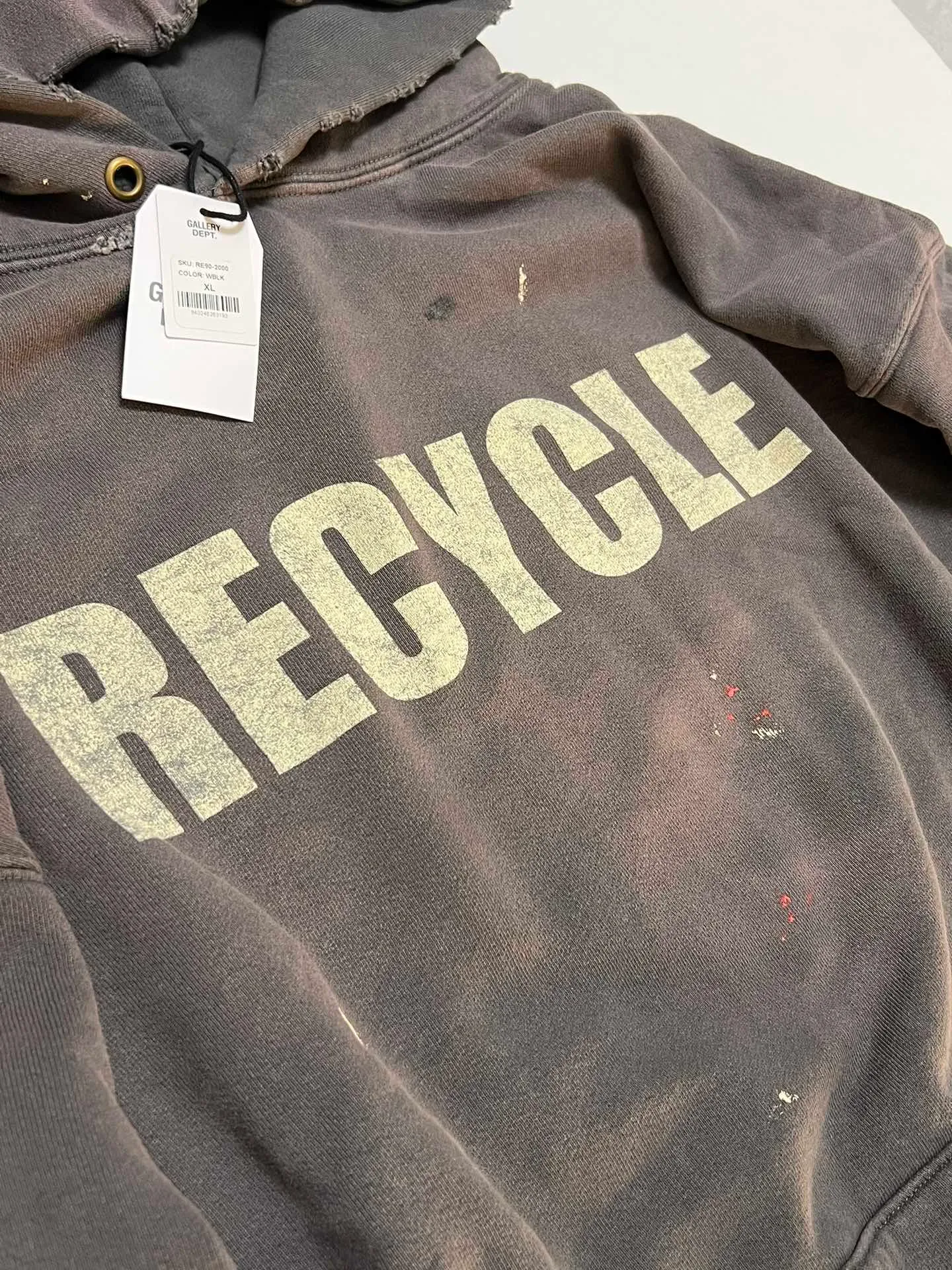 GALLERY DEPT. 90'S RECYCLE HOODIE WASHED BLACK 90'S washed hoodie with distressed eco-friendly slogans. Washed black S-XL. Ready-made garments are washed and dyed again. Multiple spots throughout the body are spray-faded. The ribs are cut and worn.